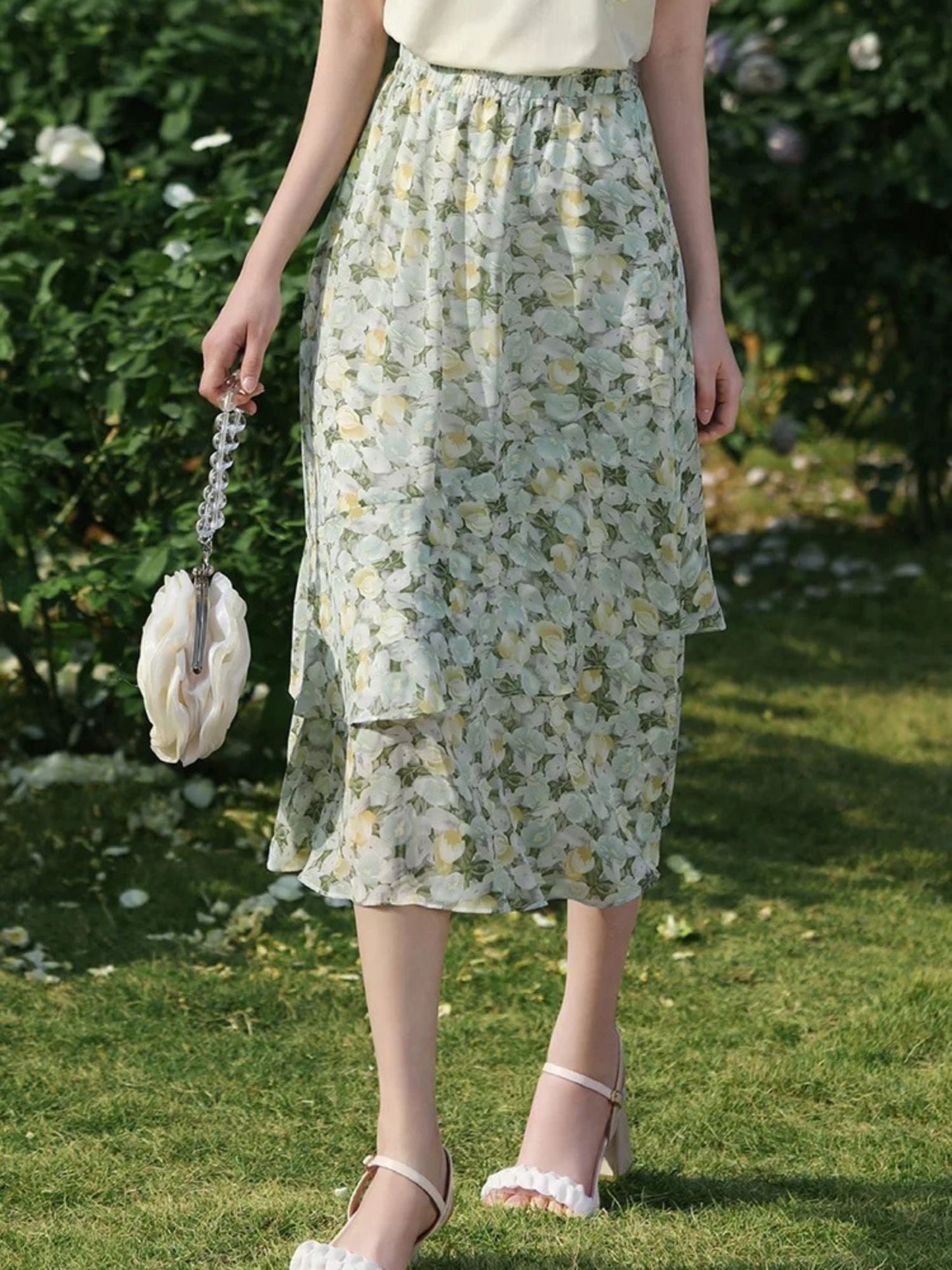 Side view of flower-printed skirt showing layered hem and soft pleats.