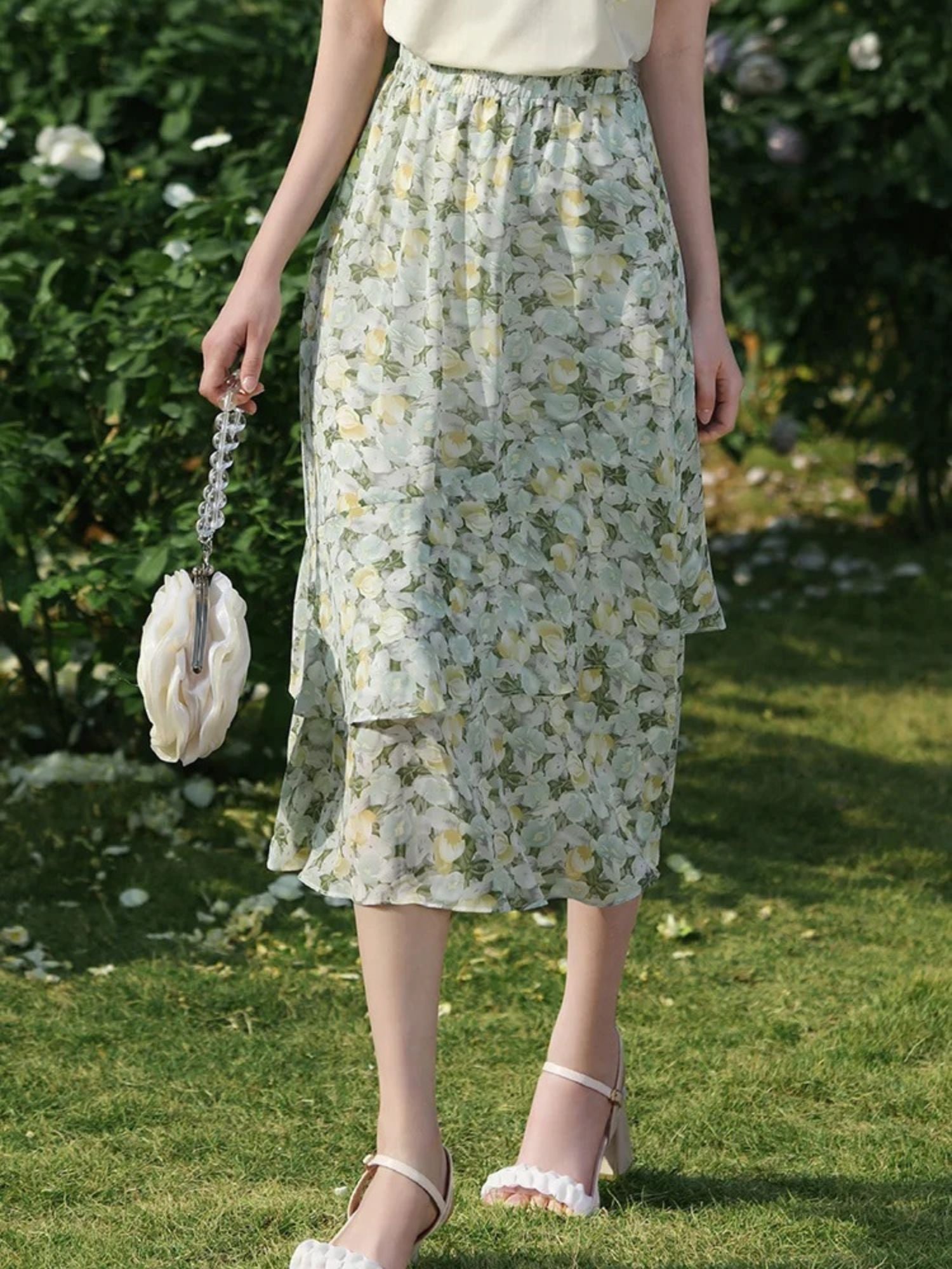 Side view of flower-printed skirt showing layered hem and soft pleats.