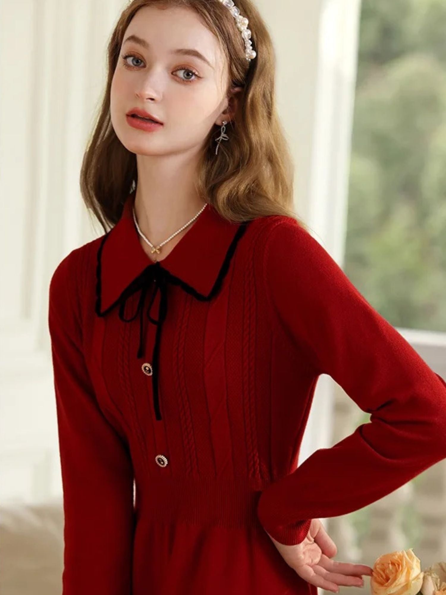 Close-up of woman in red dress with hands on hips, showing collar detail.